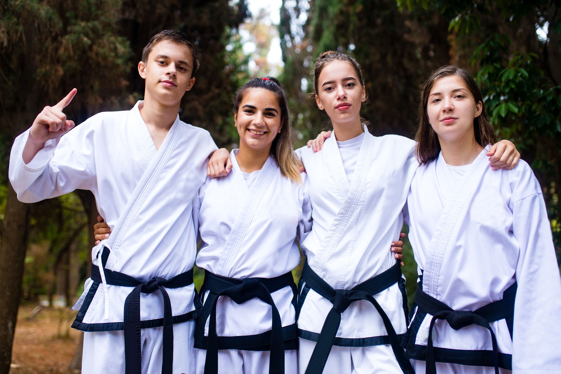 people high kicks during training of taekwondo outdoors bamboo background